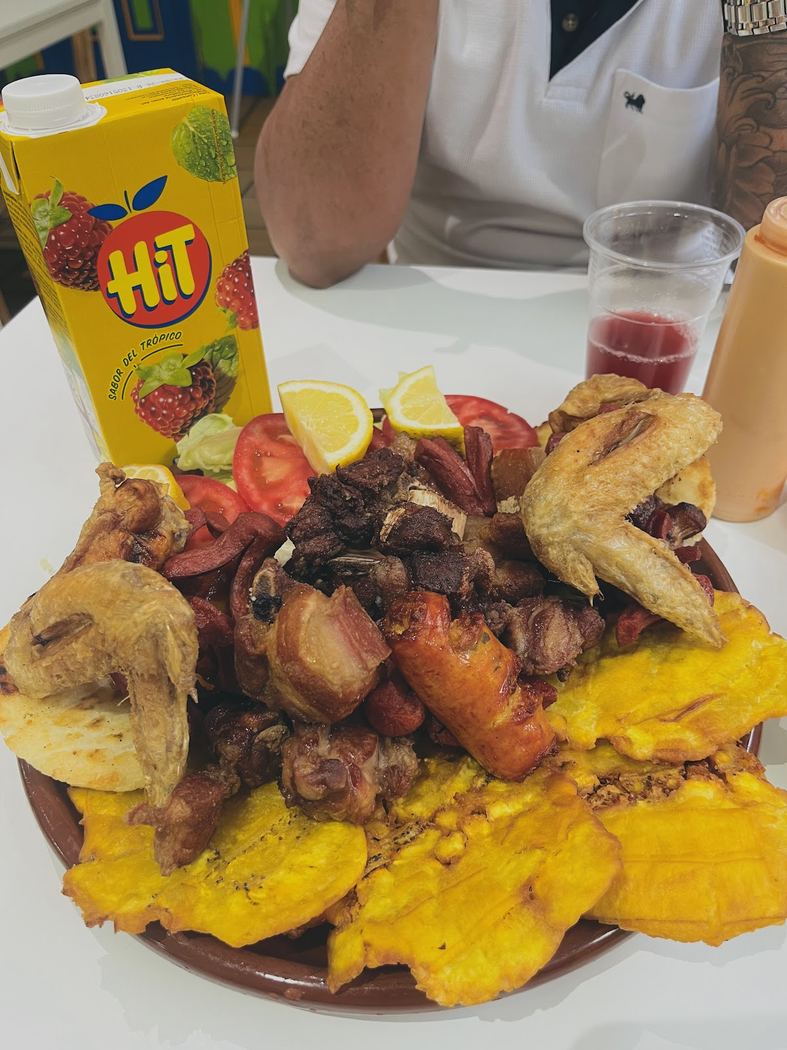 Picada variada con carnes a la parrilla, chorizo, arepas y plátano frito, ideal para compartir.
